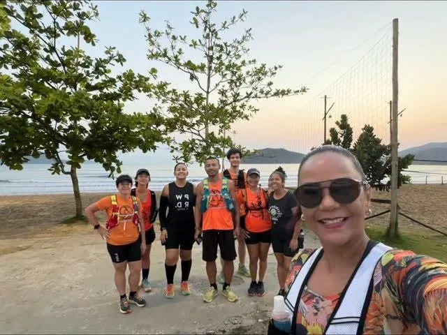 Grupo de camiseta laranja na praia, ao entardecer