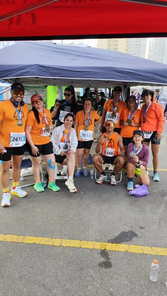 Equipe da Meu Pace, de laranja, sob uma tenda numa prova